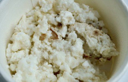 Colesterol bajo y alimentos saludables ricos en proteínas blandas. Huevo blanco revuelto solo sin yema en un tazón de papel. Fotografía de alimentos sin sabor aislada sobre fondo horizontal.