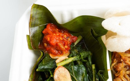 Rote Chili Sambal Cabe Merah-Gewürz auf gebratenem Kailan oder chinesischem Brokkoli-Gemüse mit gebratenen Zwiebeln. Köstliche asiatische Food-Fotografie isoliert auf horizontalem Hintergrund.