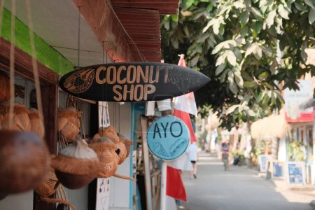 Téléchargez les photos : Promenade le long de la promenade animée des îles Gili, enseignes décorées avec "Coconut Shop" appel à l'allure tropicale. - en image libre de droit