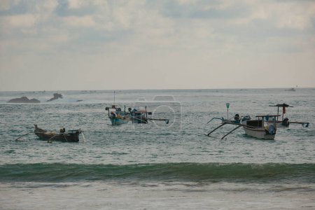 Téléchargez les photos : À Kuta Beach, Lombok, assistez à la beauté sereine des bateaux colorés reposant doucement sur le rivage. Chaque bateau raconte une histoire d'aventures maritimes - en image libre de droit