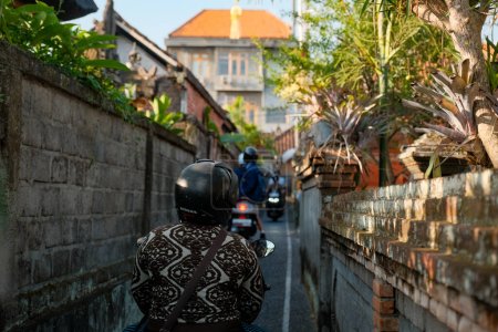 Téléchargez les photos : Embrassez l'esprit animé d'Ubud, Bali, alors que les gens explorent de charmantes rues secondaires à moto. Des couleurs vibrantes, une énergie vibrante et un sens de l'aventure remplissent l'air. - en image libre de droit