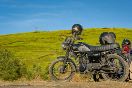 Téléchargez les photos : Une moto noire audacieuse juxtaposée à des rizières indonésiennes luxuriantes capture l'essence du voyage d'un rocker au milieu de la toile vibrante de la nature. - en image libre de droit