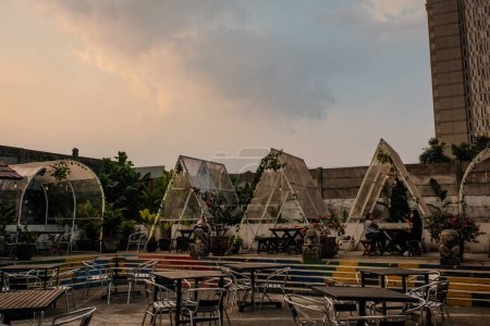 Photo for Explore the cozy ambiance of bungalow-style eating places in a Bandung food market during a cloudy sunset, where warm lights and delectable aromas create a perfect blend - Royalty Free Image
