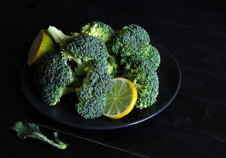 Téléchargez les photos : Fresh broccoli and lemon isolated on black background. Close-up. - en image libre de droit
