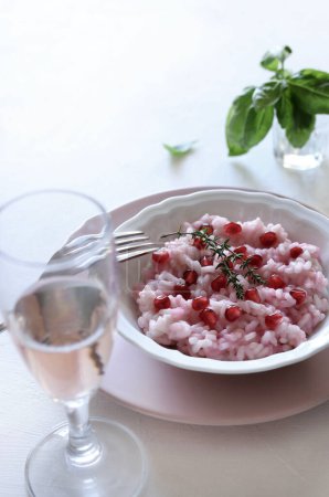 Delicious risotto with pomegranate on dark background. Vegetarian or vegan food. Directly above. Copy space.