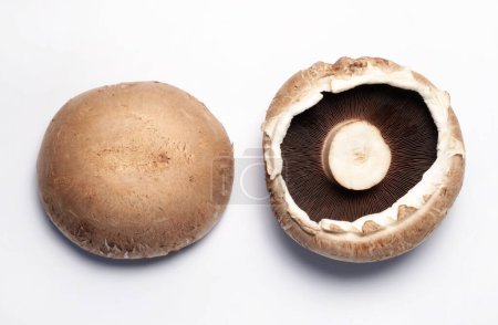 Frische rohe Portobello-Pilze isoliert auf weißem Hintergrund. Gesunde und vegetarische Kost. Direkt darüber.