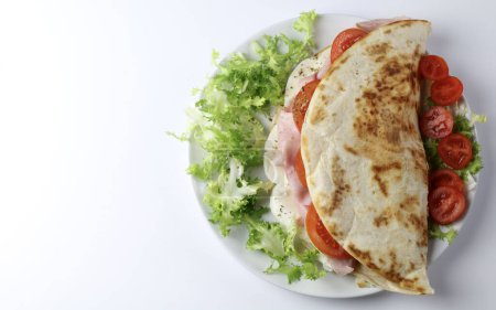 Photo for Italian piadina with ham, mozzarella, rocked salad and tomatoes isolated on white background. Overhead view. Copy space. - Royalty Free Image