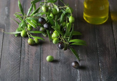 Photo for Fresh olives and olive oil isolated on wooden table. Healthy food. Overhead view. Copy space. - Royalty Free Image