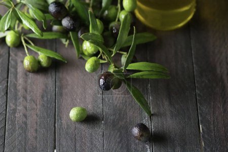 Téléchargez les photos : Olives fraîches et huile d'olive isolées sur une table en bois. Une nourriture saine. Vue aérienne. Espace de copie. - en image libre de droit