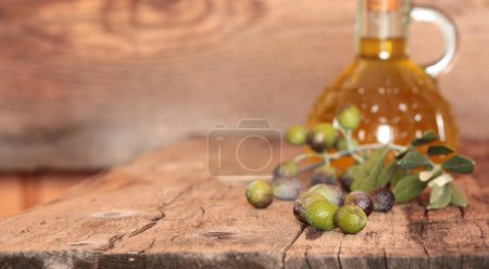 Téléchargez les photos : Une bouteille d'huile d'olive extra vierge fraîche et d'olive isolée sur fond bois. Concept de nature et d'aliments sains, sains et naturels. Vue aérienne. Espace de copie. - en image libre de droit
