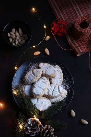 Photo for Ricciarelli pastries, typical Sienese Christmas sweet made with almond on dark background. Christmas decorations. Traditional Italian desserts. - Royalty Free Image