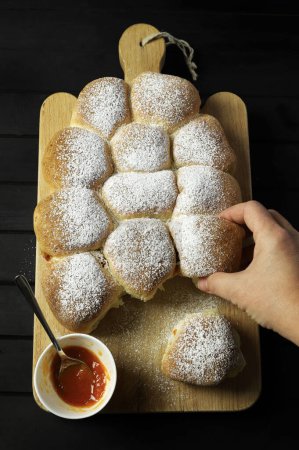Homemade Austrian buns filled with apricot jam isolated on black background. Sweet buns. Yeast dough cakes. Sweet Danube