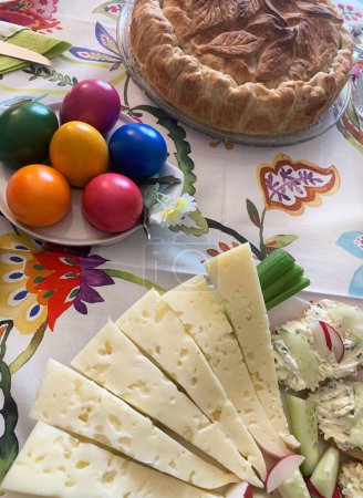 Traditional Easter food. Easter cake (torta Pasqualina) with spinach and ricotta, Oliver salad, Easter eggs, appetizer, cheese. Family gathering concept. Directly above.