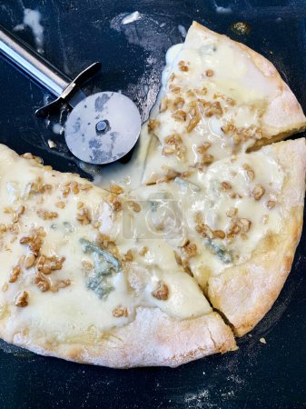 Photo for Homemade baked tasty pizza with gorgonzola, mozzarella and walnuts on a tray. Italian food. Directly above. - Royalty Free Image