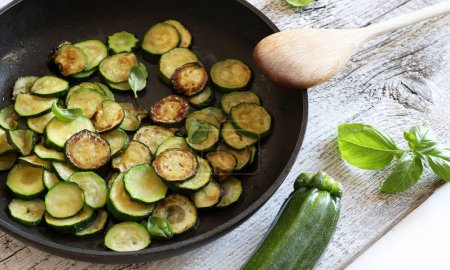 Pan-fried courgettes flavored with basil. Homemade cooking concept. Directly above.