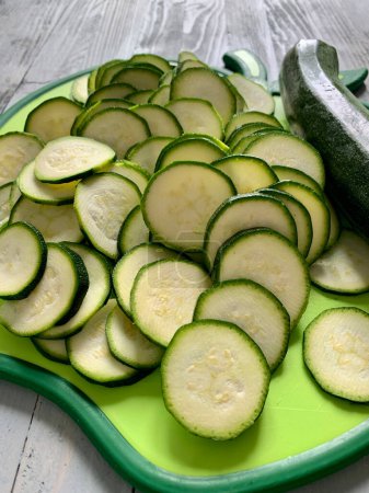 Photo for Courgettes sliced into rounds on a cutting board. Healthy and vegetarian food. Directly above. - Royalty Free Image