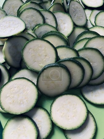 Photo for Courgettes sliced into rounds on a cutting board. Healthy and vegetarian food. Directly above. - Royalty Free Image