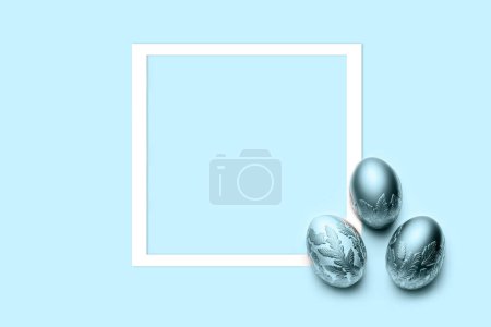 Téléchargez les photos : Trois œufs bleus avec cadre sur fond bleu. Pose plate, vue du dessus, espace de copie. - en image libre de droit