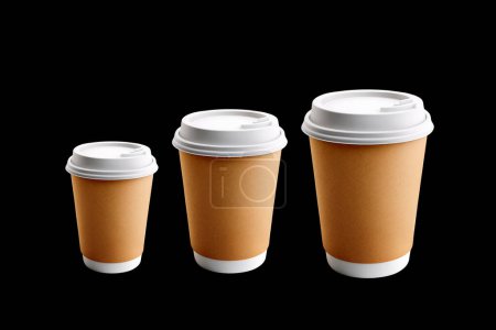 Téléchargez les photos : Tasses à café à emporter dans des tailles différentes. Isolé sur fond noir - en image libre de droit