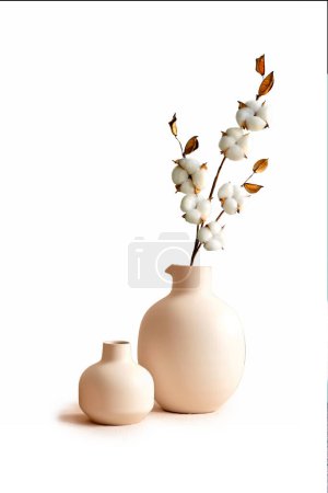 Téléchargez les photos : Vases en céramique beige avec branches de coton sèches. Couleurs neutres tendance décoration intérieure . - en image libre de droit