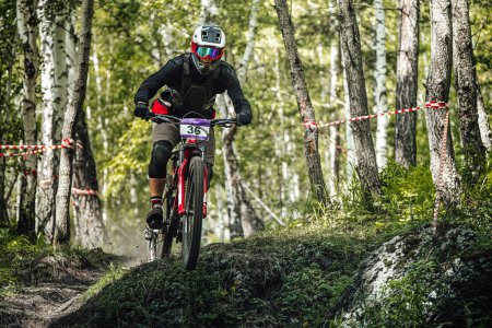Photo for Green Glade, Russia - July 16, 2022: athlete rider downhill forest trail race in Ural Downhill Cup - Royalty Free Image