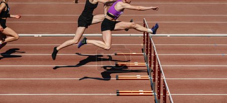Téléchargez les photos : Chelyabinsk, Russia - June 23, 2022:group female athletes run 100 meters with hurdles in Athletics Championship - en image libre de droit