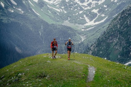 Photo for Arkhyz, Russia - July 2, 2022: two male athlete walking mountain trail in Arkhyz X Run - Royalty Free Image