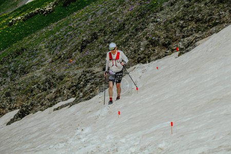 Photo for Arkhyz, Russia - July 2, 2022: male athlete walking snowy uphill in Arkhyz X Run - Royalty Free Image