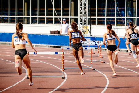 Foto de Mujeres corriendo 400 - metros obstáculos en la competencia de atletismo - Imagen libre de derechos