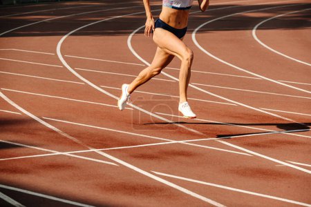 Foto de Atleta femenina corriendo en pista de estadio - Imagen libre de derechos