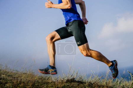 Photo for Sochi, Russia -  September 19, 2017: male runner running uphill trail in Asics shoes and shorts Mizuno - Royalty Free Image