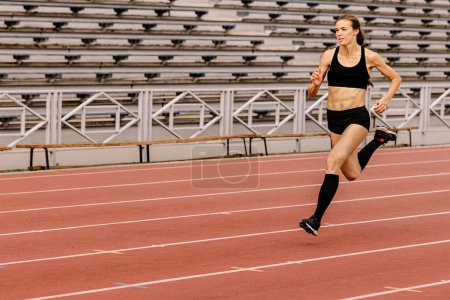 Foto de Corredor femenino corriendo en pista de estadio - Imagen libre de derechos