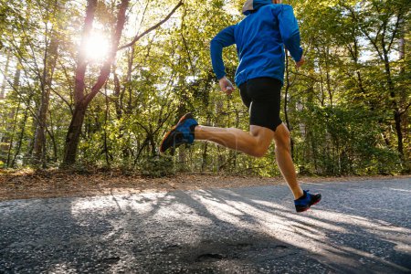 Téléchargez les photos : Male runner running road in park in light of sun - en image libre de droit