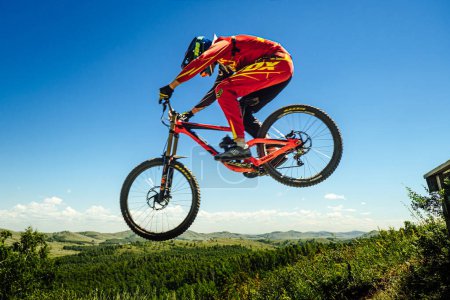 Téléchargez les photos : Green Glade; Russia - July 16; 2022: athlete gap jump in protective clothing Fox racing during Ural Downhill Cup - en image libre de droit