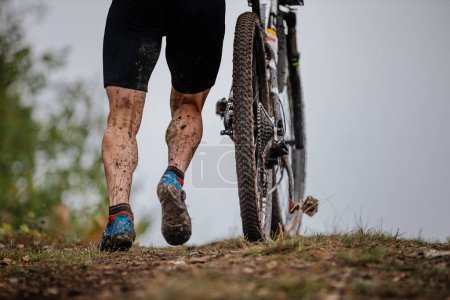 Téléchargez les photos : Athlète monte avec son vélo de montagne. laisse tomber la saleté sur les pieds et le vélo. compétition cycliste cross-country - en image libre de droit