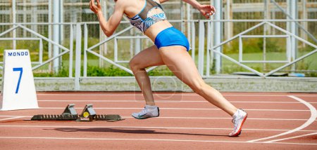 Photo for Female sprinter running start at stadium, Nike spikes shoes for running, sports photos - Royalty Free Image