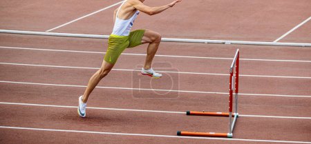 Photo for Male athlete running 400 meters hurdles, Nike spikes shoes and tights, summer sports games - Royalty Free Image
