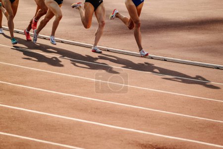 Photo for Legs group female athletes run middle distance race at stadium, spikes shoes for running Nike, sports photo - Royalty Free Image