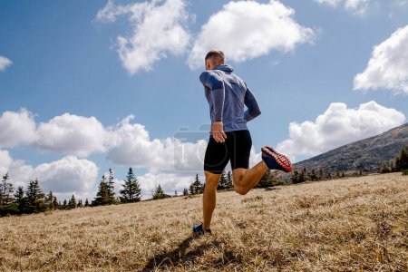 Foto de Atleta masculino corredor cross country corriendo cuesta arriba, verano al aire libre, deportes foto - Imagen libre de derechos