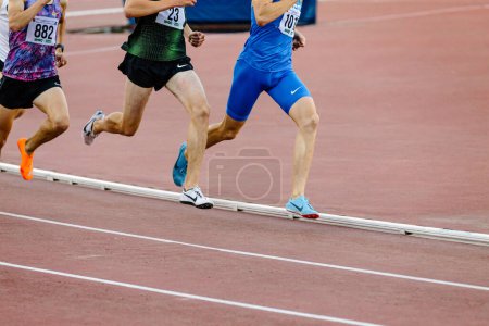 Photo for Group runners athletes on middle distance running race, Nike spikes shoes and clothes, summer sports games - Royalty Free Image