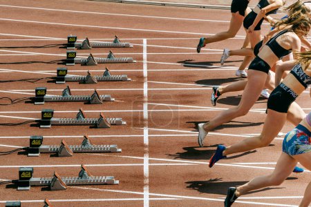 Photo for Female runners athletes in Nike spikes start race running from starting blocks Alge-Timing, world championship athletics competition, sports editorial photo - Royalty Free Image