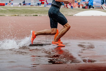 Photo for Male athlete runner in Nike spikes shoes running steeplechase race, world championship athletics competition, sports editorial photo - Royalty Free Image