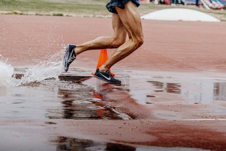 Téléchargez les photos : Jambes athlète coureur masculin en Nike pointes chaussures course steeplechase, championnat du monde de compétition d'athlétisme, sport photo éditoriale - en image libre de droit