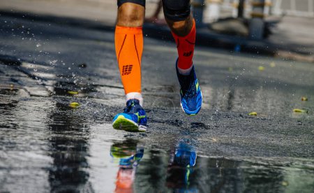 Téléchargez les photos : Coureur masculin en chaussettes de compression CEP et chaussures Mizuno sur l'eau, course marathon ville, photo éditoriale de sport - en image libre de droit