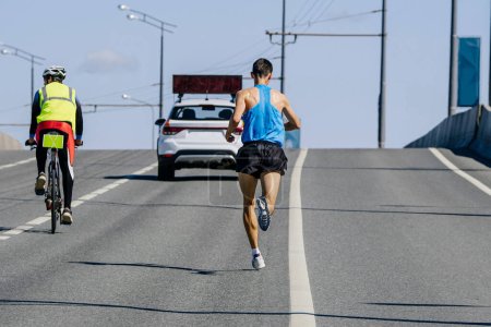 Mann Führer Marathonlauf für Tempo-Auto, männlicher Athlet joggt bergauf Überführung, Ausdauersport Wettbewerb