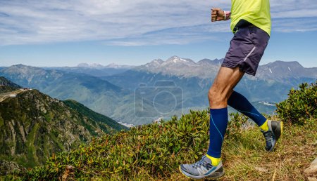 legs runner athlete in compression socks run down mountain, skyrunning race competition