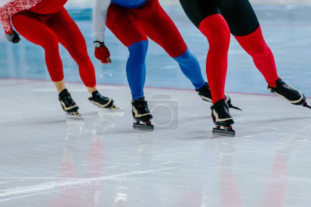 Foto de Tres patinadores masculinos corren juntos la competencia de patinaje de velocidad de calentamiento, juegos de deportes de invierno - Imagen libre de derechos