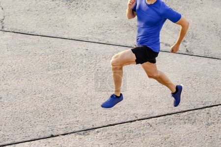 Foto de Delgado muscular corredor masculino corriendo camino de hormigón, vista superior trotar hombre en el entrenamiento - Imagen libre de derechos