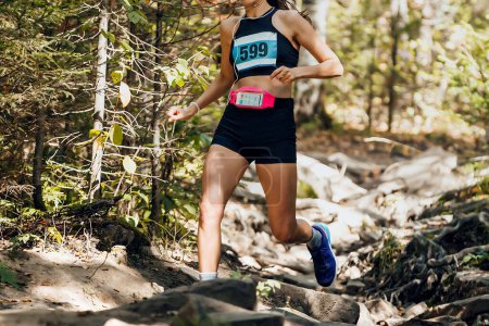 Foto de Chica corredor atleta corriendo piedras pista maratón carrera en bosque - Imagen libre de derechos