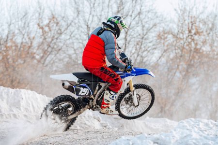 Photo for Motocross rider riding winter off-road motorcycle racing, snow splashes from under rear wheel - Royalty Free Image